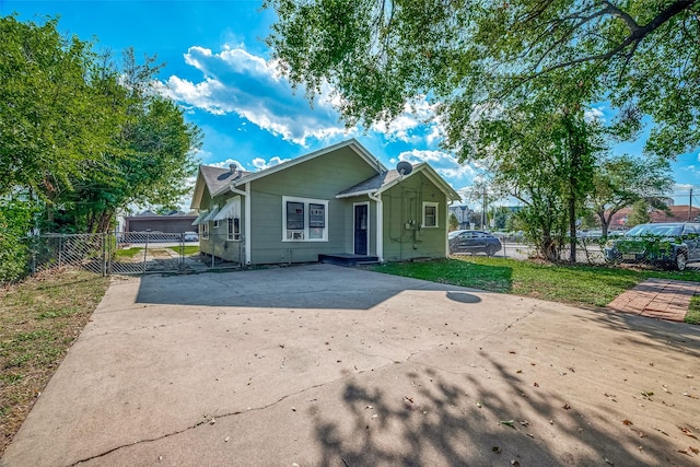 bungalow-style home with a gate, concrete driveway, and fence