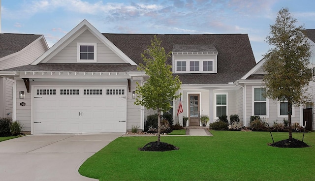 view of front facade with a front yard, concrete driveway, a garage, and roof with shingles