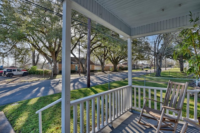 deck featuring a porch and a yard