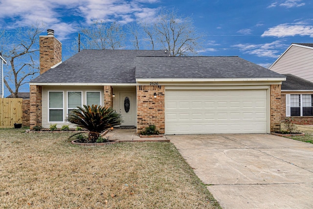 ranch-style home featuring a front yard, driveway, a chimney, a garage, and brick siding