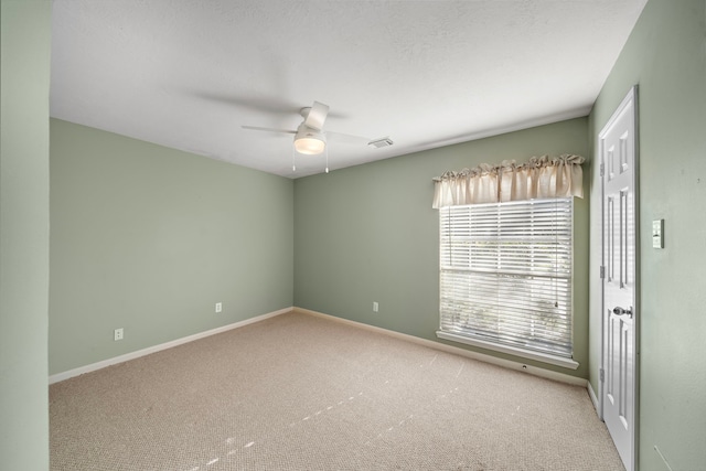 spare room with visible vents, ceiling fan, baseboards, and carpet