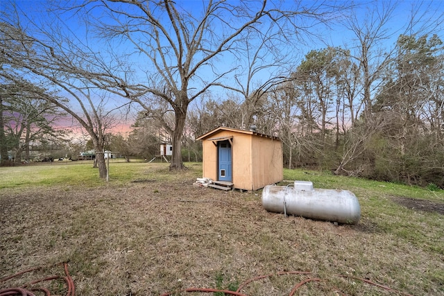 yard at dusk featuring an outbuilding and a shed