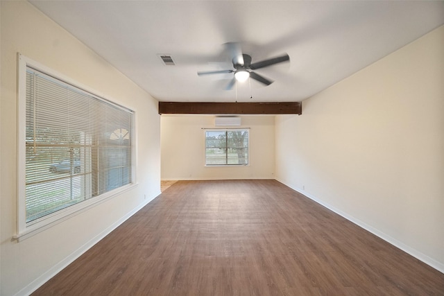 empty room with visible vents, a wall mounted AC, baseboards, and wood finished floors