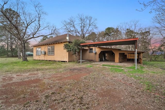 exterior space with a carport, driveway, and an outbuilding