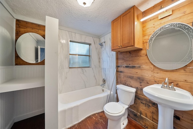 full bath with toilet, a textured ceiling, shower / tub combination, wood finished floors, and wood walls