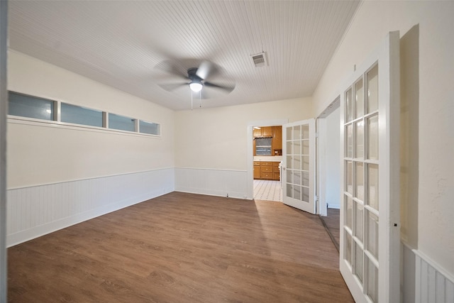 spare room with visible vents, dark wood finished floors, wainscoting, and french doors