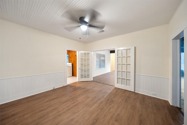 empty room featuring wood finished floors, french doors, visible vents, and wainscoting