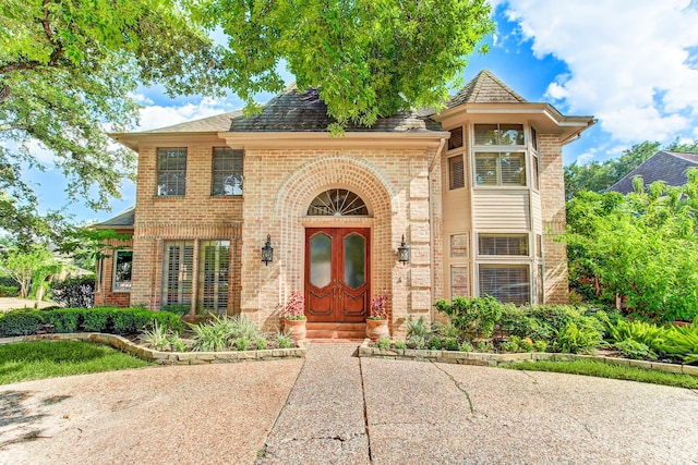 view of front of house with brick siding and a shingled roof