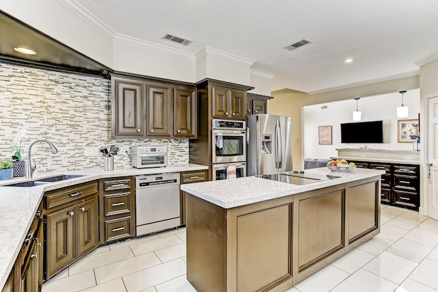 kitchen with a sink, visible vents, appliances with stainless steel finishes, and a center island