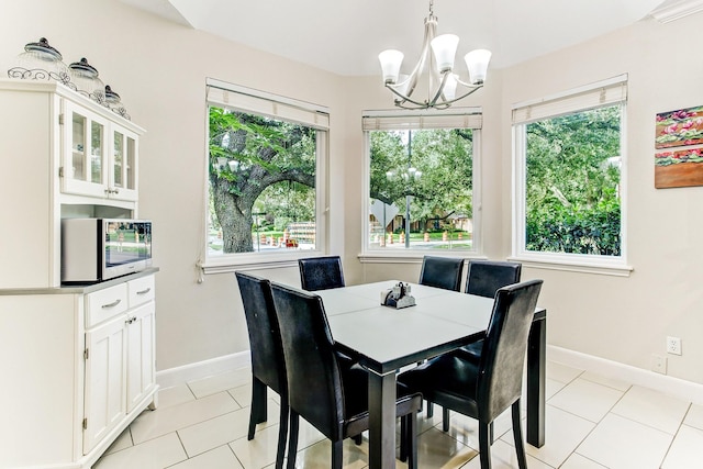 dining room with an inviting chandelier, light tile patterned flooring, and baseboards