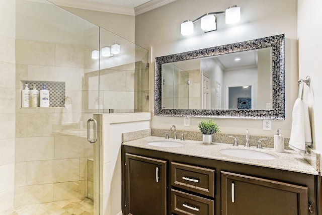 bathroom with a sink, ornamental molding, and a shower stall