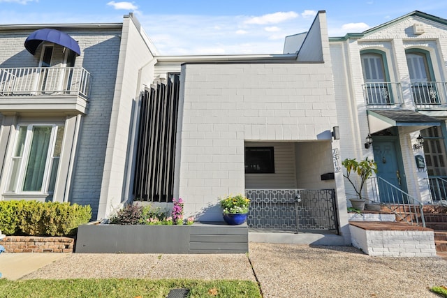 exterior space with brick siding and a balcony