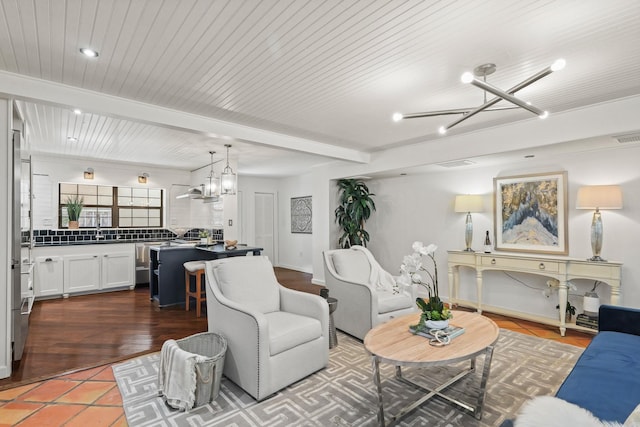 tiled living room with beam ceiling and an inviting chandelier