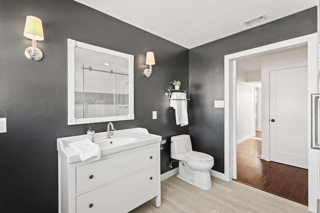 full bath featuring visible vents, toilet, a shower, baseboards, and vanity