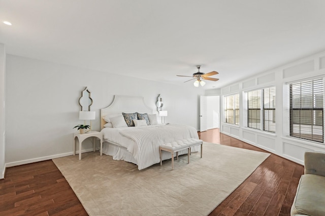 bedroom with a ceiling fan, wood finished floors, and baseboards