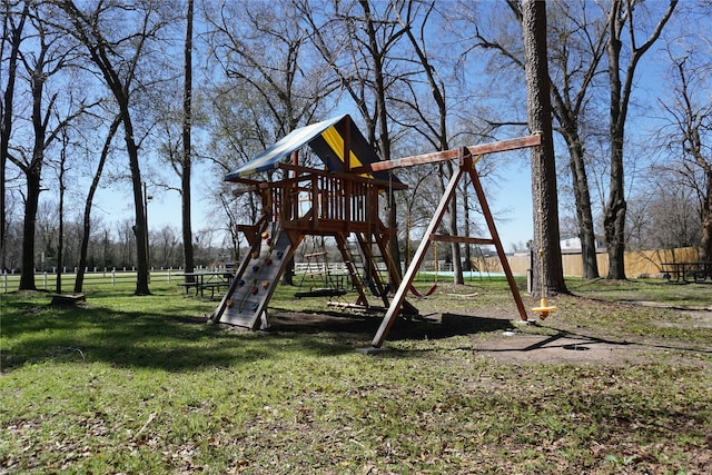 view of jungle gym featuring a lawn and fence