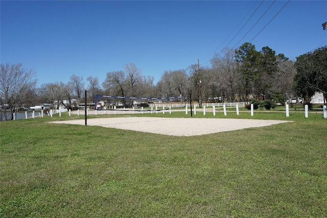 view of community with volleyball court and a lawn