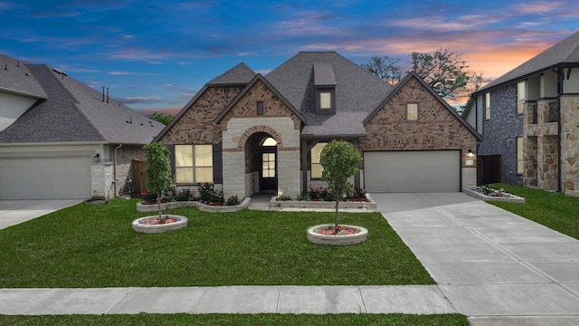 view of front of house featuring a garage, a lawn, roof with shingles, and driveway