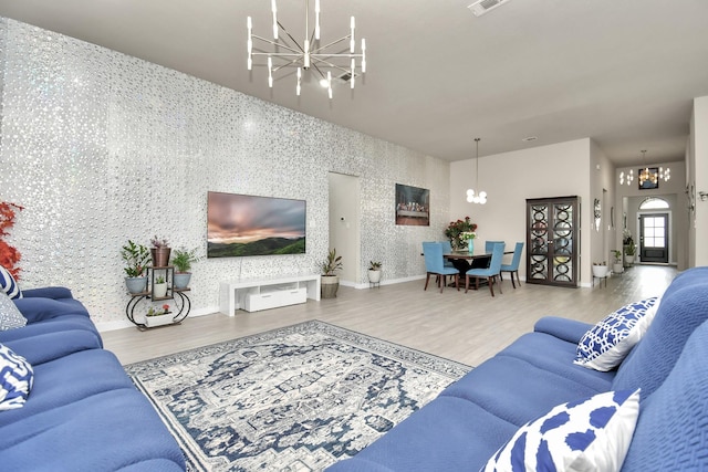 living room featuring baseboards, wood finished floors, a chandelier, and wallpapered walls