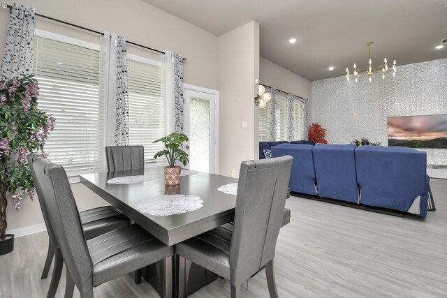 dining area featuring light wood-style flooring, a notable chandelier, and recessed lighting