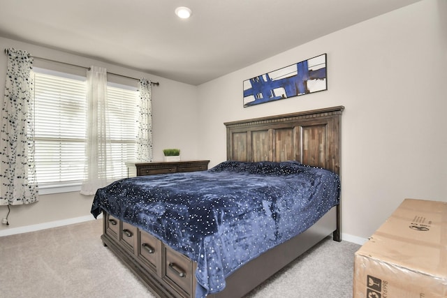 bedroom with light carpet and baseboards