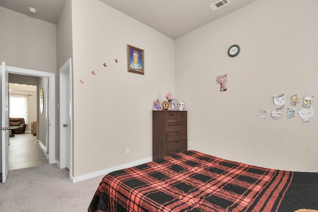 bedroom with baseboards, visible vents, and light carpet