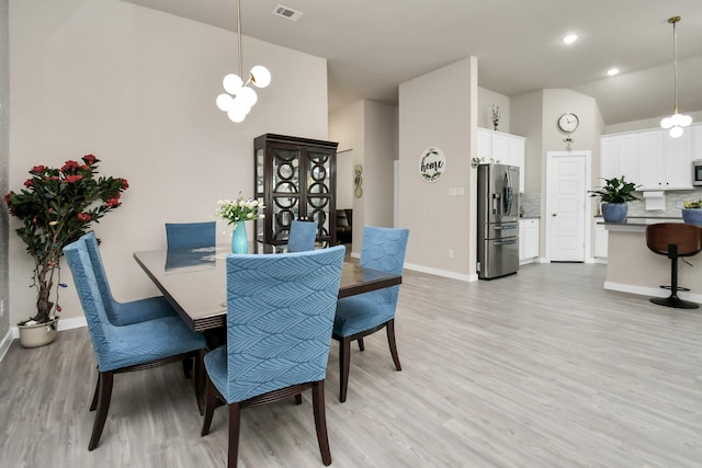 dining area featuring lofted ceiling, baseboards, visible vents, and light wood finished floors