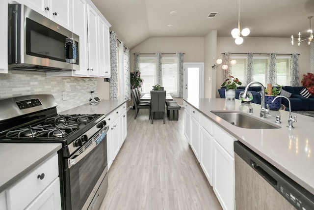 kitchen featuring visible vents, stainless steel appliances, light countertops, and a sink