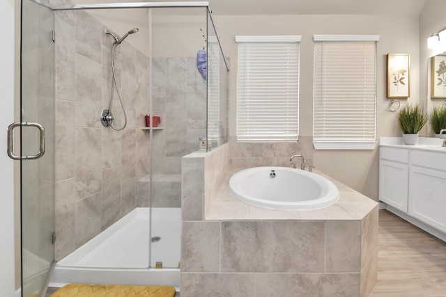 bathroom featuring vanity, a shower stall, and a garden tub