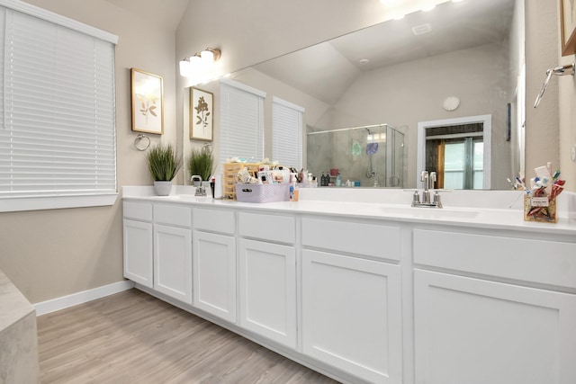 full bath featuring lofted ceiling, wood finished floors, a stall shower, and a sink