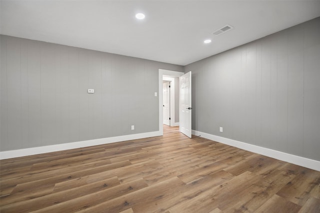 unfurnished room with recessed lighting, wood finished floors, visible vents, and baseboards