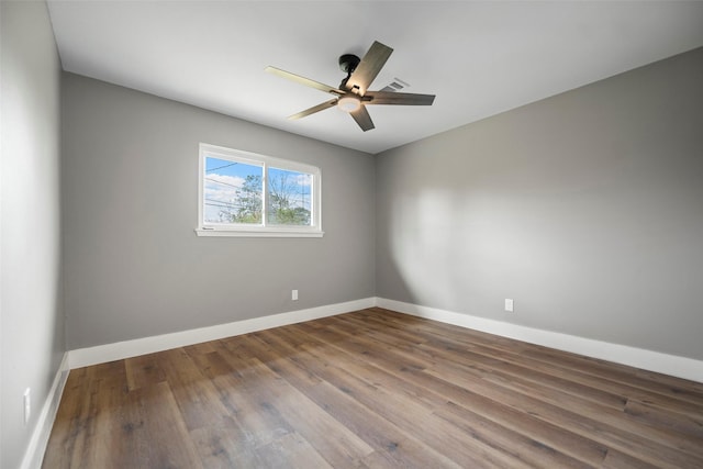 unfurnished room featuring baseboards, wood finished floors, and a ceiling fan