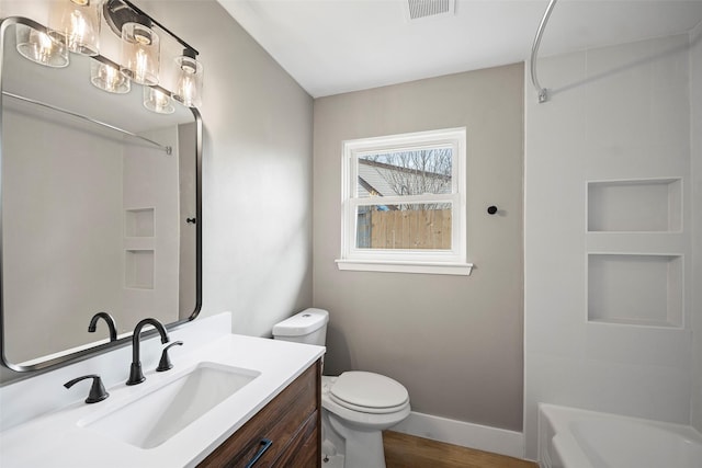 bathroom featuring visible vents, baseboards, toilet, wood finished floors, and vanity