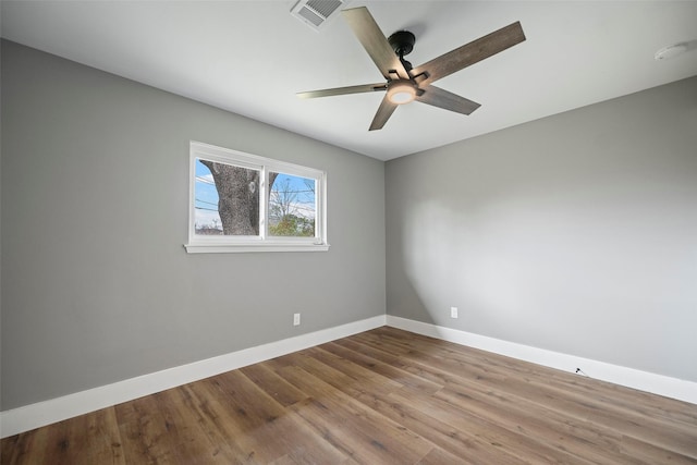 unfurnished room with visible vents, a ceiling fan, baseboards, and wood finished floors