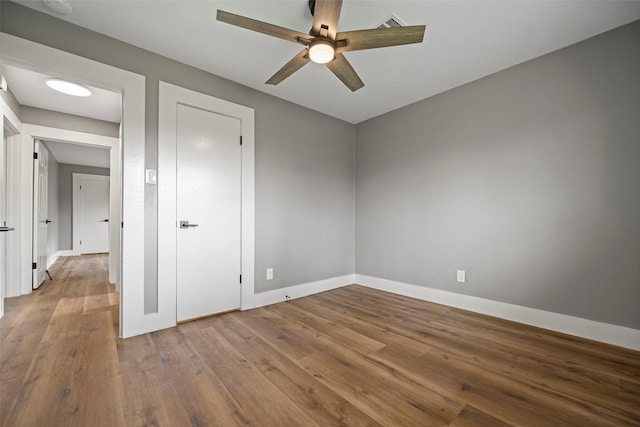 unfurnished bedroom with a ceiling fan, baseboards, and wood finished floors