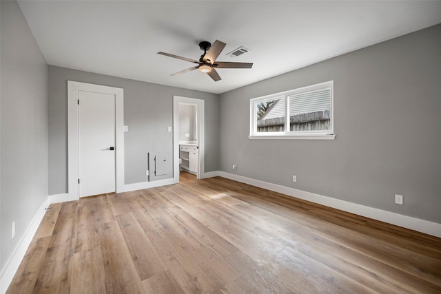 unfurnished bedroom featuring a ceiling fan, baseboards, visible vents, light wood-type flooring, and connected bathroom