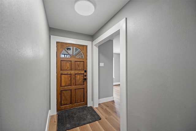 entryway with baseboards and light wood finished floors