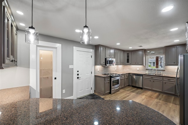 kitchen with recessed lighting, backsplash, stainless steel appliances, and a sink