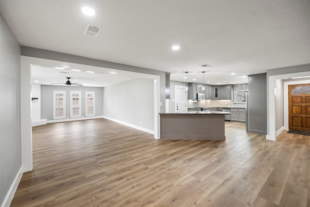 kitchen featuring open floor plan, light wood-type flooring, visible vents, and gray cabinetry