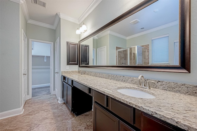 full bath with visible vents, a sink, a shower stall, crown molding, and a spacious closet