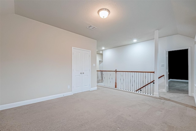 carpeted empty room featuring visible vents, recessed lighting, baseboards, and lofted ceiling