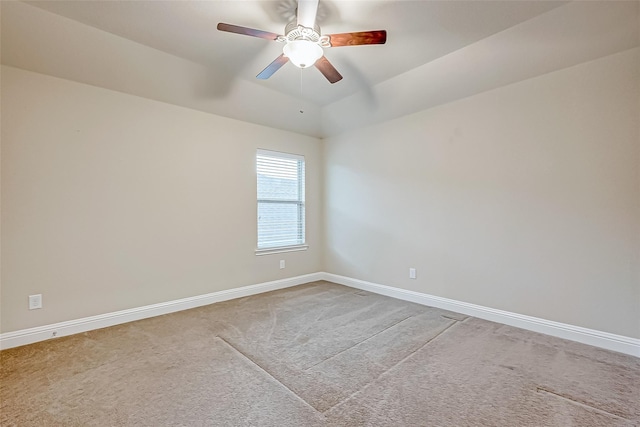 carpeted spare room with lofted ceiling, a ceiling fan, and baseboards