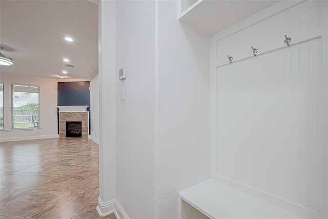 mudroom with recessed lighting, baseboards, a tiled fireplace, and light tile patterned floors