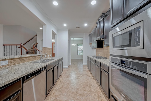 kitchen with a sink, visible vents, light stone counters, and appliances with stainless steel finishes