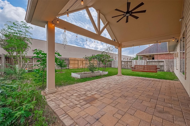 view of patio / terrace featuring a vegetable garden, a ceiling fan, and a fenced backyard