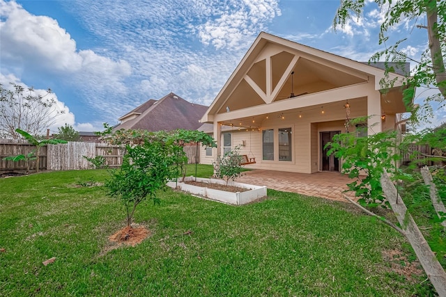 back of house featuring a yard, a patio area, and fence