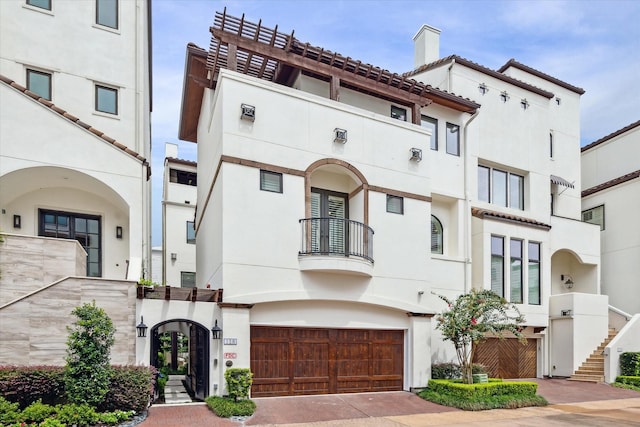 view of front of property featuring stucco siding, a tiled roof, a chimney, and decorative driveway