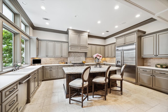 kitchen with visible vents, gray cabinetry, a kitchen breakfast bar, a center island, and stainless steel appliances