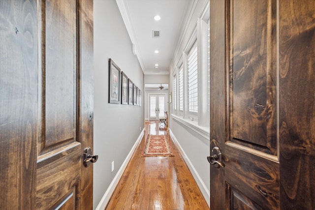 corridor with baseboards, light wood finished floors, visible vents, recessed lighting, and crown molding