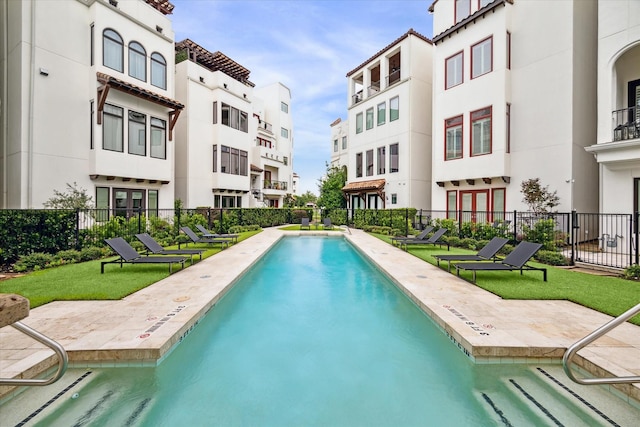 pool featuring a lawn and fence